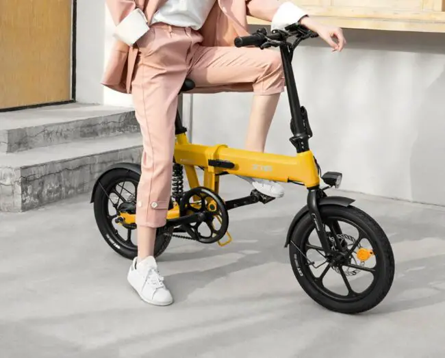 女士坐在黄色的himo z16折叠电动自行车上