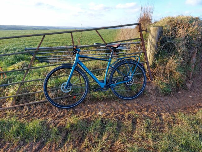 ribble al e hybrid resting against a gate in the countryside